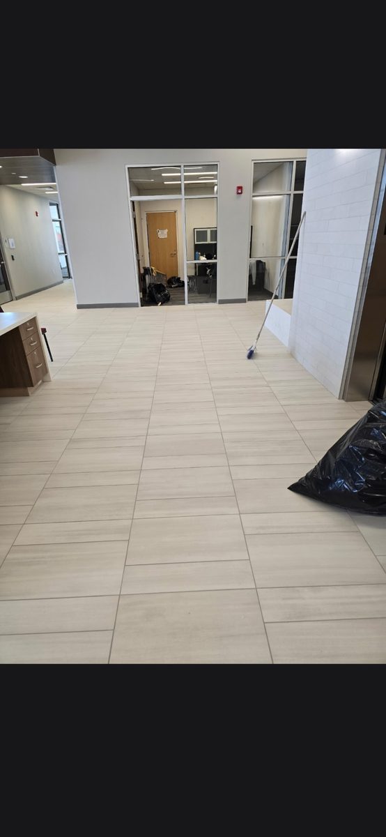 Large-format tile floor running through a commercial corridor